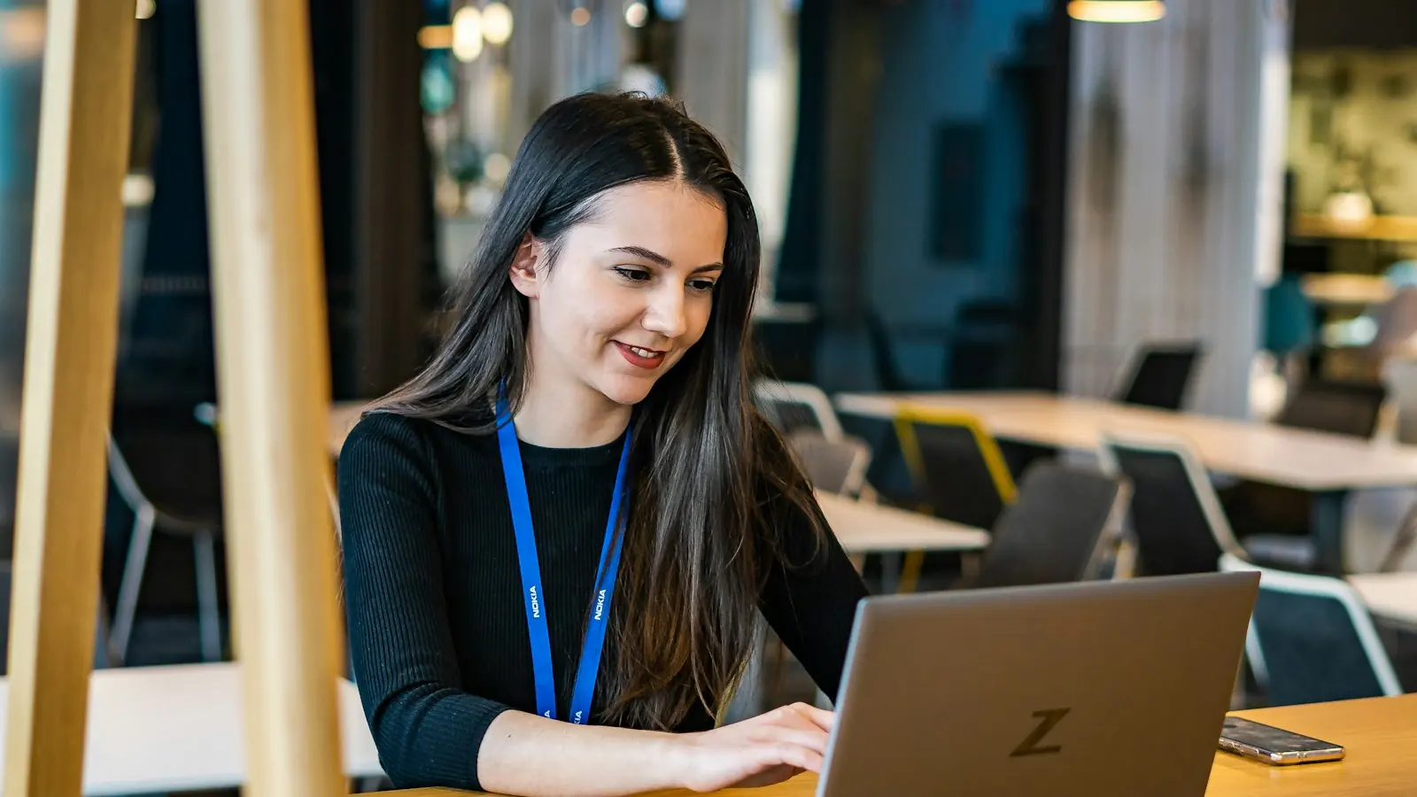 Podnikateľka s úsmevom pracuje vo fakturačnom programe na notebooku