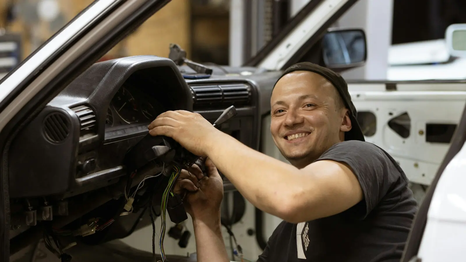 Usmiaty automechanik pri práci v servise